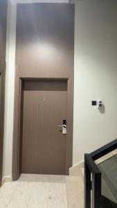 a brown door in a room with a wall at the garden in Hail