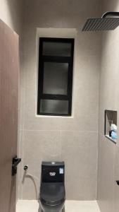 a bathroom with a black toilet and a window at the garden in Hail