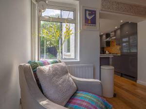 a living room with a couch and a window at Seagrass Cottage - 3bed, Private Parking, Secluded Garden, Minutes from Whitstable town in Whitstable