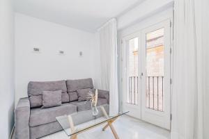 a living room with a couch and a glass table at Apartamentos Domus con parking gratuito in Granada