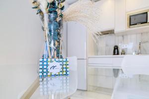 a vase with a bunch of flowers in a kitchen at Apartamentos Domus con parking gratuito in Granada +76 photos
