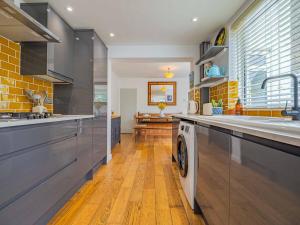 a kitchen with a sink and a washing machine at Seagrass Cottage - 3bed, Private Parking, Secluded Garden, Minutes from Whitstable town in Whitstable