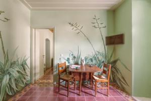 a dining room with a table and chairs and plants at Cactus Hydra - Art Apartments in Hydra