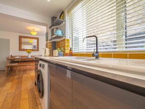 a kitchen with a sink and a washing machine at Seagrass Cottage - 3bed, Private Parking, Secluded Garden, Minutes from Whitstable town in Whitstable +47 photos