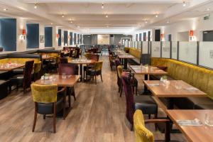 a restaurant with wooden tables and yellow chairs at New Lanark Mill Hotel in Lanark