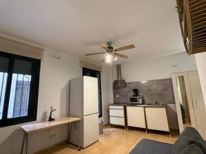 a kitchen with a white refrigerator and a ceiling fan at Lupe Mediterranean Loft,150m from the Beach Blanes Center in Blanes