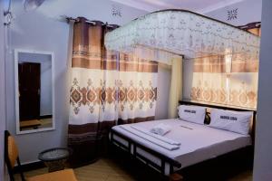 a bedroom with a bed with a canopy at Marindo Lodge Moshi in Moshi