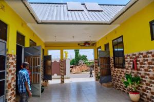 a man standing outside of a yellow building at Marindo Lodge Moshi in Moshi +13 photos