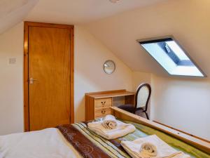 a attic bedroom with a bed and a skylight at The Hen Hoose in Creebridge
