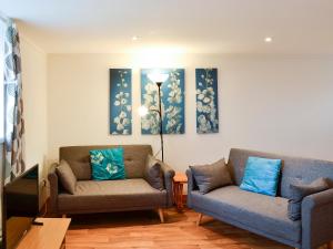 a living room with two chairs and two paintings on the wall at The Hen Hoose in Creebridge