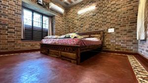 a bedroom with a bed in a brick wall at Mutram Heritage Stay in Kanchipuram