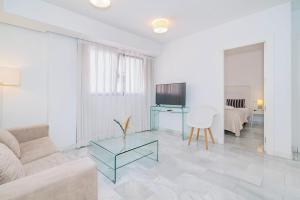 a living room with a couch and a table at Apartamentos Domus con parking gratuito in Granada