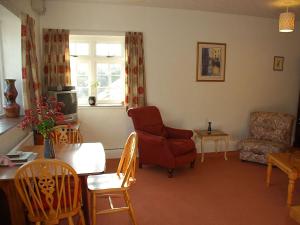 a living room with a red chair and a table at The Pottery Annexe in Baslow