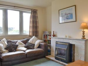 a living room with a couch and a fireplace at Ribblestones in Austwick