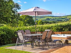 a table and chairs with an umbrella on a patio at Ash Lodge At Lon Lodges in Nantmel