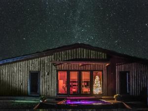 a barn at night with a christmas tree in the window at Ash Lodge At Lon Lodges in Nantmel