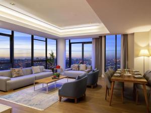 a living room with couches and tables and windows at Movenpick Living Istanbul West in Istanbul