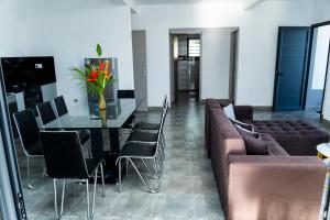 a dining room with a table and a couch at Résidence Vahi-Ni, Villa Faniry in Hell-Ville