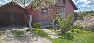 a house with a fence and a tree in the yard at Apartman Sigma Zlatar in Nova Varoš