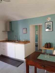 a kitchen with a sink and a table in a room at Appartamento LaLieve - casaDELRESTO in Gaiola +16 photos