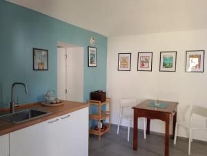 a kitchen with a sink and a table at Appartamento LaLieve - casaDELRESTO in Gaiola
