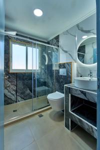 a bathroom with a toilet and a sink and a shower at Villa Escapes By The Beach in Sidari +52 photos