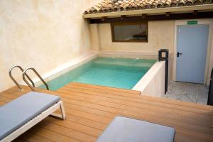 a lap pool in a building with a table and chairs at Arena Centro Rooms&Suites in Seville +73 photos