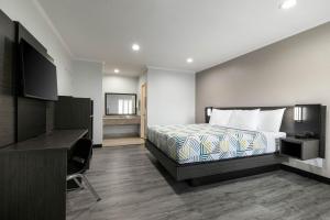 a hotel room with a bed and a desk at Motel 6-Anaheim, CA - Convention Center in Anaheim