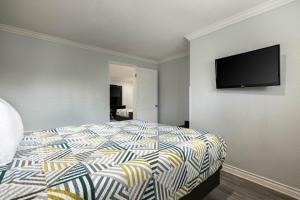 a bedroom with a bed with a television on the wall at Motel 6-Anaheim, CA - Convention Center in Anaheim