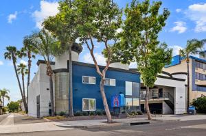 a blue building with palm trees in front of it at Motel 6-Anaheim, CA - Convention Center in Anaheim