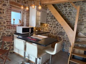 a kitchen with a sink and a counter with stools at Le Menes in Andenne
