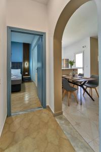 a dining room and living room with a table and chairs at Villa Escapes By The Beach in Sidari