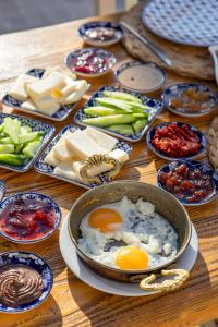 a table with eggs in a pan and other foods at ALAÇATI ROKA TAŞ BUTİK HOTEL in Çeşme
