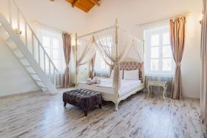 a bedroom with a canopy bed and a staircase at ALAÇATI ROKA TAŞ BUTİK HOTEL in Çeşme