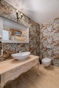 a bathroom with a sink and a mirror and a toilet at ALAÇATI ROKA TAŞ BUTİK HOTEL in Çeşme +28 photos