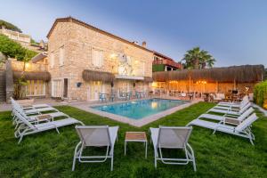 a resort with a pool and chairs and a building at ALAÇATI ROKA TAŞ BUTİK HOTEL in Çeşme