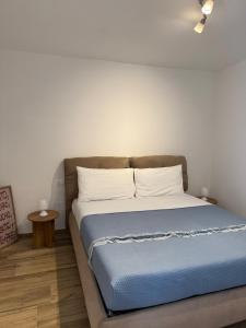 a bedroom with a bed with blue sheets and white pillows at B&B Aura in Pontecagnano +11 photos