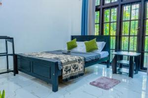 a bedroom with a bed and a table at Hill Top Villa Kandy in Ambatenna