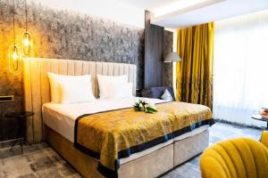 ein Hotelzimmer mit einem Bett und einem gelben Stuhl in der Unterkunft Hotel Pasha in Mostar + 112 Fotos