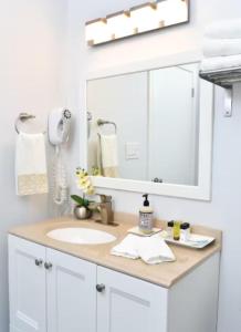 a bathroom with a sink and a large mirror at Downtown Suite #4 - Wharf View in Newport