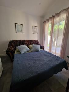 a bedroom with a bed and a large window at L'escale Provençale in Pierrelatte