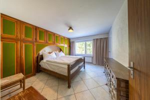 a bedroom with a bed in a room with green walls at Alpenblick-Apartment mit Pool & Sauna in St. Moritz