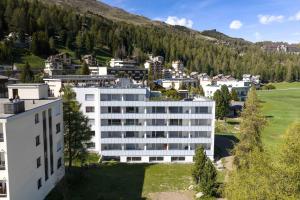 an aerial view of a white building in a city at Alpenblick-Apartment mit Pool & Sauna in St. Moritz