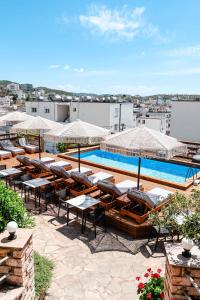 a resort with a pool and tables and chairs at Hotel Milo Ksamil in Ksamil
