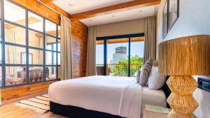 a bedroom with a large bed and large windows at Bio et Bois -Luxury Bio Farm- in Moulay Yacoub