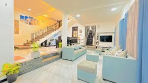 a living room with two couches and a tv at Hill Top Villa Kandy in Ambatenna