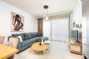 a living room with a blue couch and a table at Athenean Oasis in Ellinikon in Athens