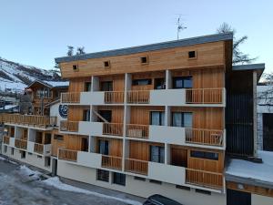 an apartment building with snow on the ground at Résidence le Schuss Studio Montagne en bas des pistes in Vars