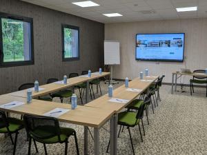 a conference room with tables and chairs and a projection screen at ibis Styles Contres-Cheverny in Le Controis En Sologne +93 photos
