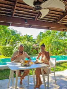 a man and woman sitting at a table eating food at Bungalow VILLA Cha Cha in Ko Yao Noi
